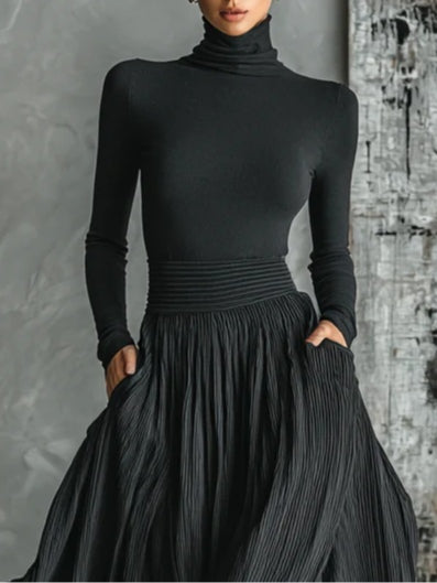 Fashionable set of a black, fitted turtleneck and a pleated skirt